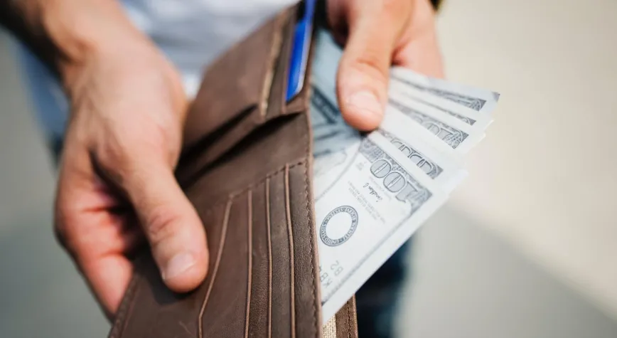 Man Holding Brown Leather Bi-fold Wallet With Money in It